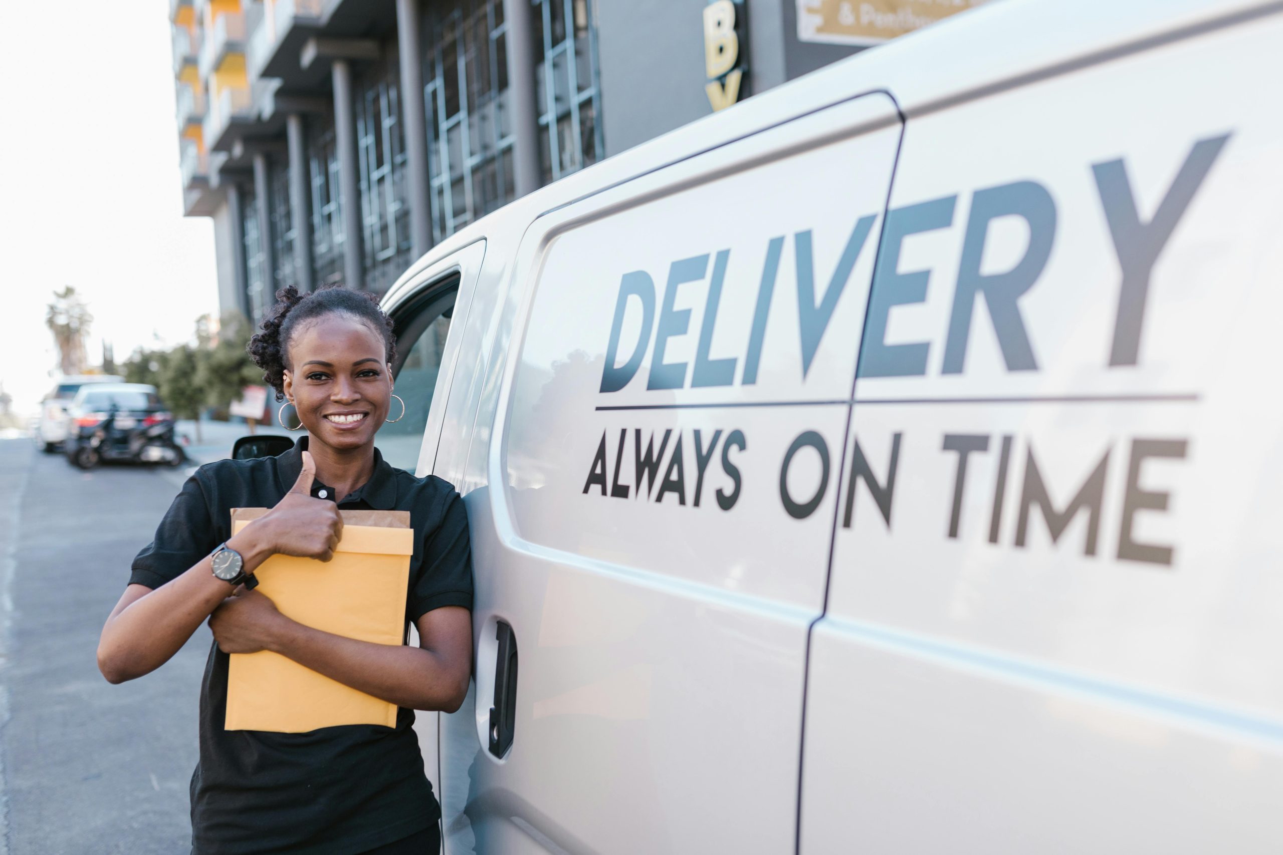 Woman in Yellow Polo Shirt and Black Skirt Standing Beside White Van